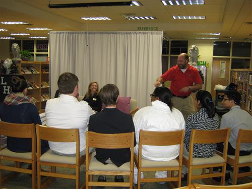 A parent demonstrating an energy conservation technique at the STEAM Club's Energy Expo 