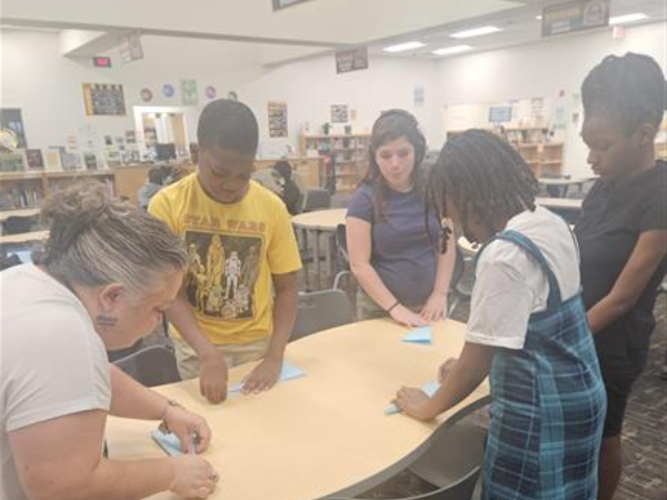 students folding airplanes