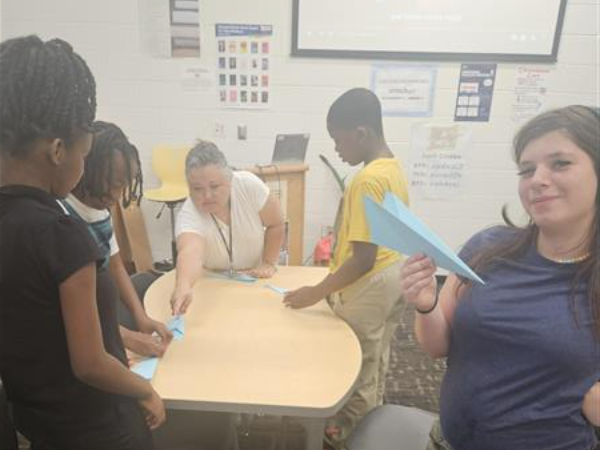 students folding airplanes